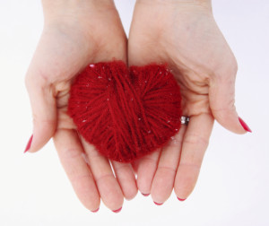 woman holding red Wool heart in hand